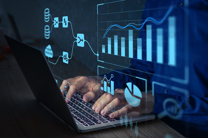 Analyst working with business analytics and data management on a computer.